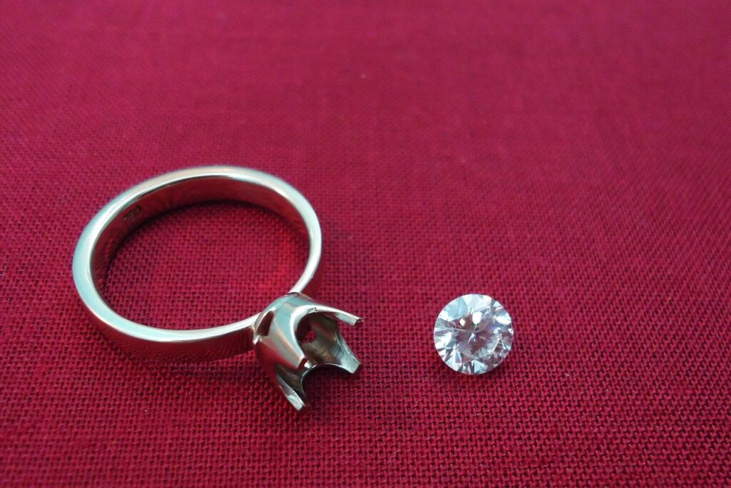Ringschiene mit leerer Krappenfassung und loser Diamant daneben