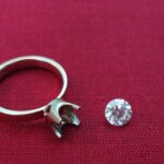 Ringschiene mit leerer Krappenfassung und loser Diamant daneben